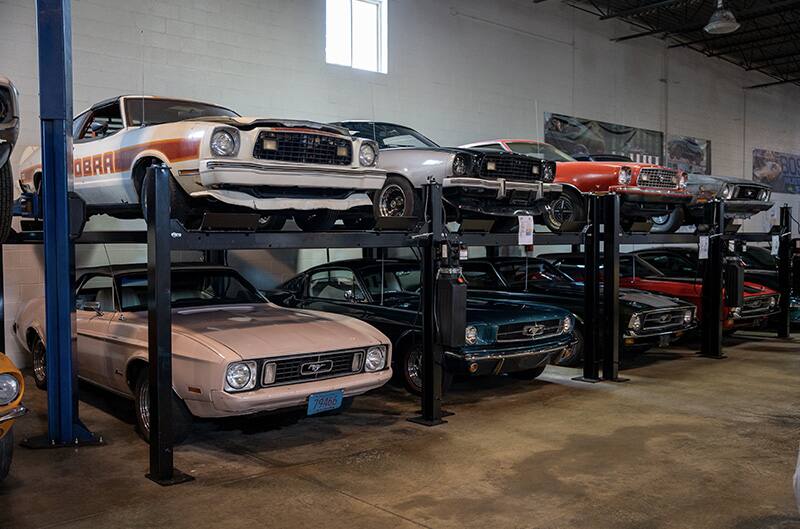 Mustangs stored in warehouse on lifts